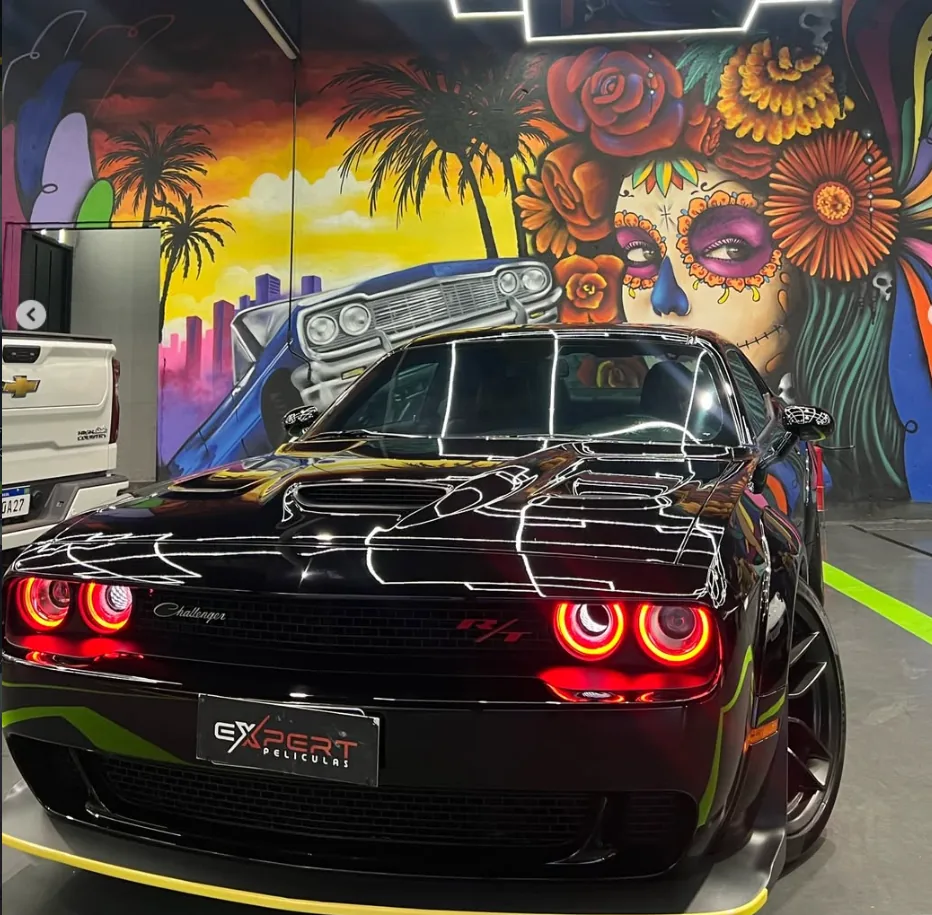 Dodge Challenger preto com faróis vermelhos acesos